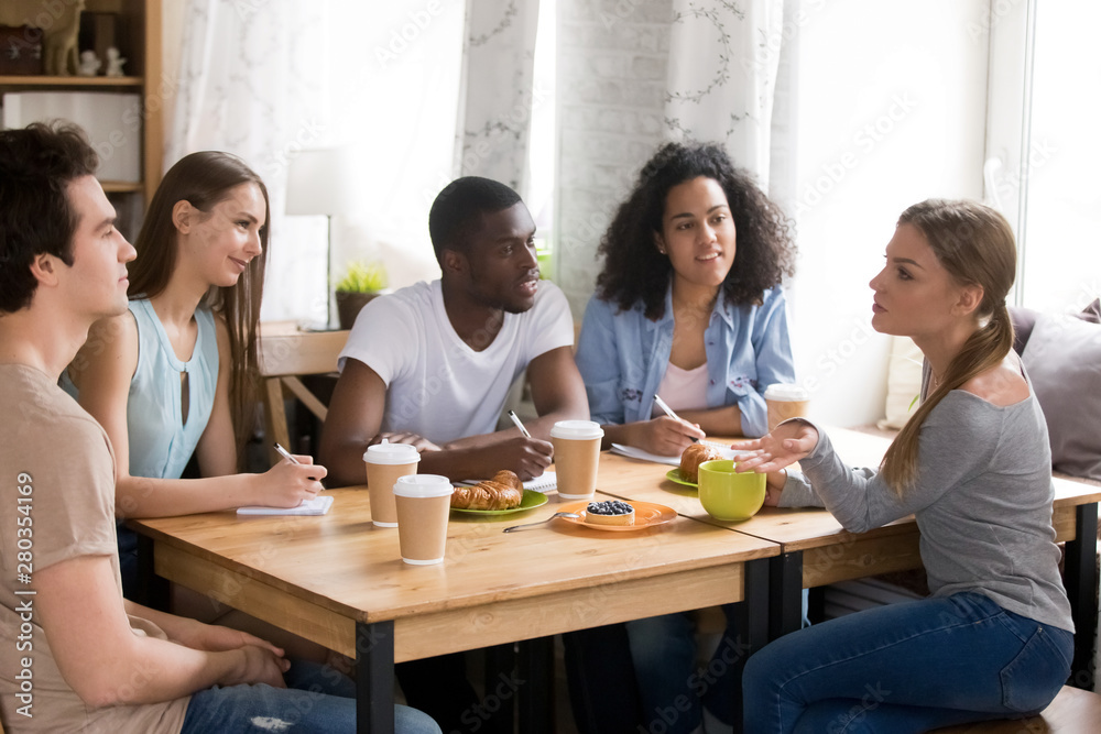 Diverse cheerful students preparing together for exam. Diverse cheerful students preparing together for exam.
