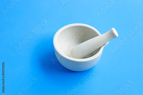 Canvas Print Mortar and pestle on blue background.