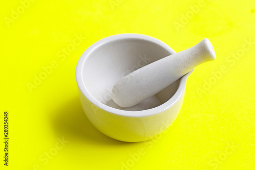 Mortar and pestle on green background.