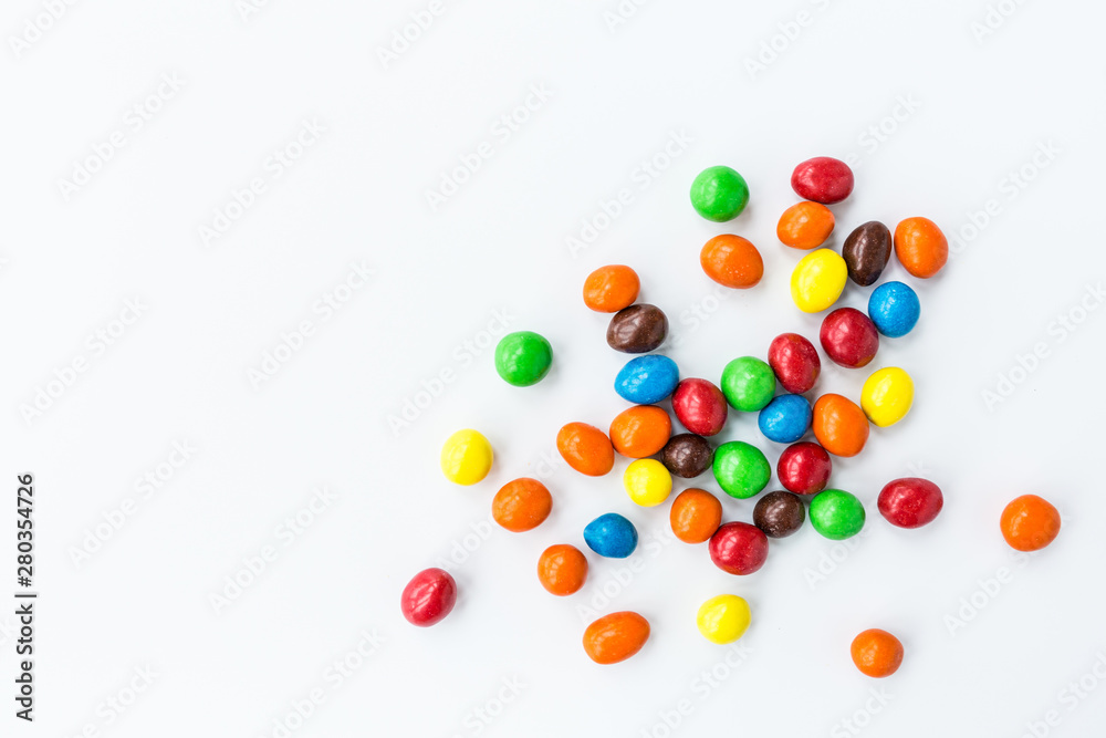Candy lying on white background. Bright and Colorful sweets top view. Flat lay image. Copy space template. Unhealthy eating concept
