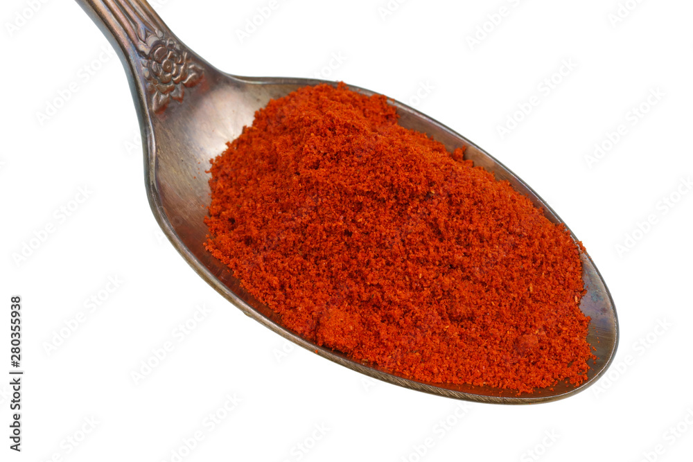 In the old golden spoon there is a small pile of food - ground hot chili pepper spice isolated macro In the old golden spoon there is a small pile of food - ground hot chili pepper spice isolated macro