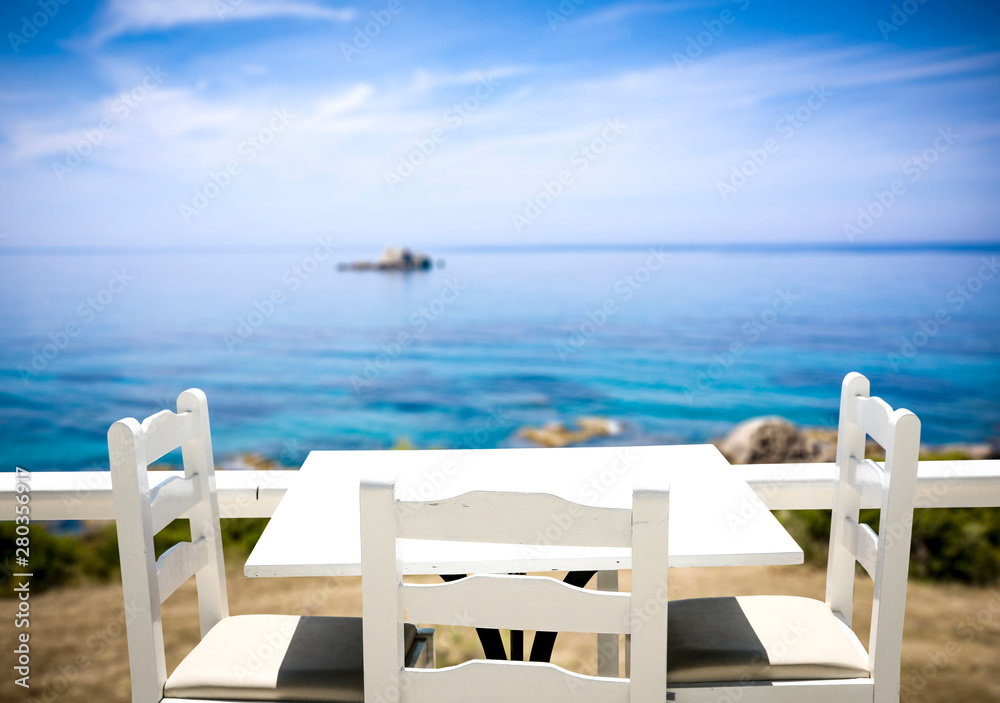 Table background with beautiful blue ocean and sandy beach view in distance.