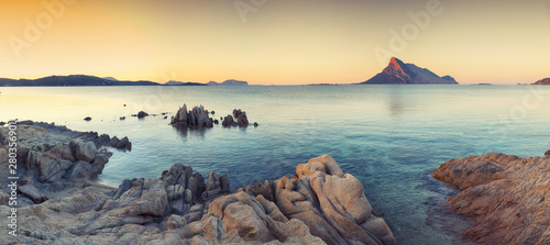 Fototapeta Naklejka Na Ścianę i Meble -  Fantastic azure water with rocks near beach Porto Taverna at sunset