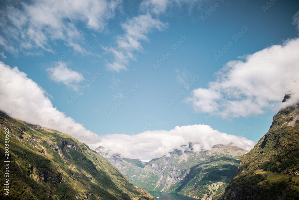 view of mountains with clouds in geiranger