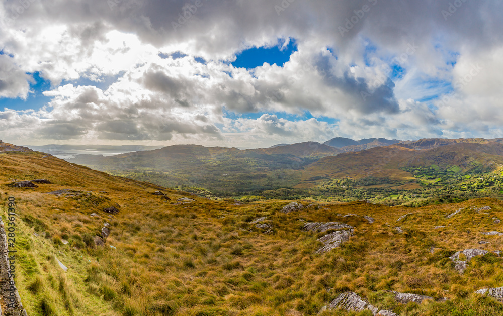 Typical Irish landscape with green meadows and rough mountains Typical Irish landscape with green meadows and rough mountains
