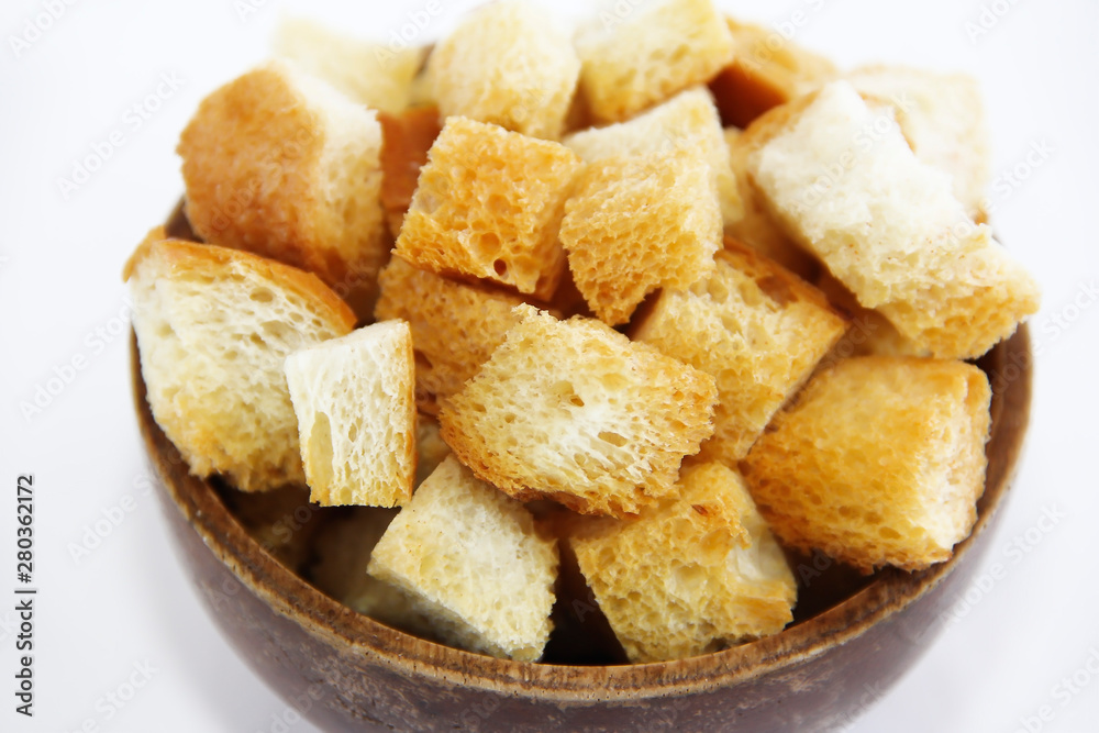 fried dry white bread crackers in a wooden plate on a white background