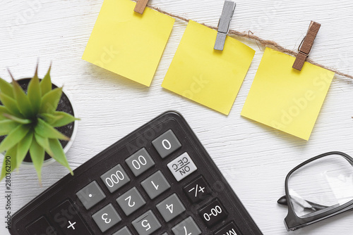 Business to do list mock up. Blank paper stickers, calculator, green plant on the white table background. photo