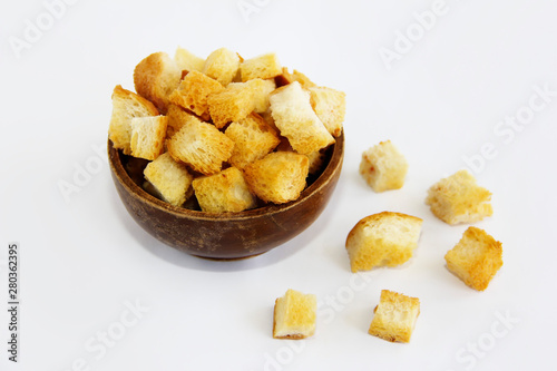 fried dry white bread crackers in a wooden plate on a white background