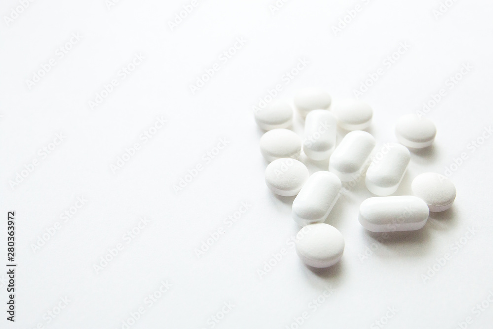 White capsules isolated on white background, copyspace for text, selective focus, top view. Pain meds, health, pills for the treatment of the concept of drug abuse