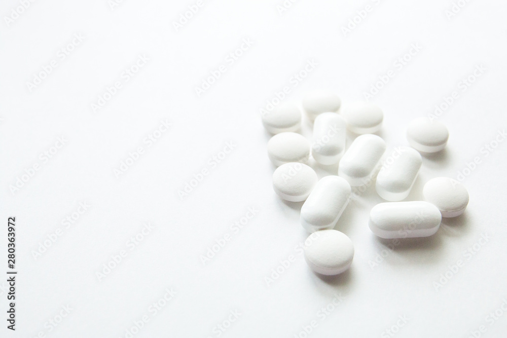 White capsules isolated on white background, copyspace for text, selective focus, top view. Pain meds, health, pills for the treatment of the concept of drug abuse White capsules isolated on white background, copyspace for text, selective focus, top view. Pain meds, health, pills for the treatment of the concept of drug abuse
