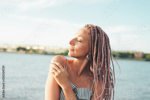 Carefree young woman with african braids enjoy her life on beach, summer vacation time
