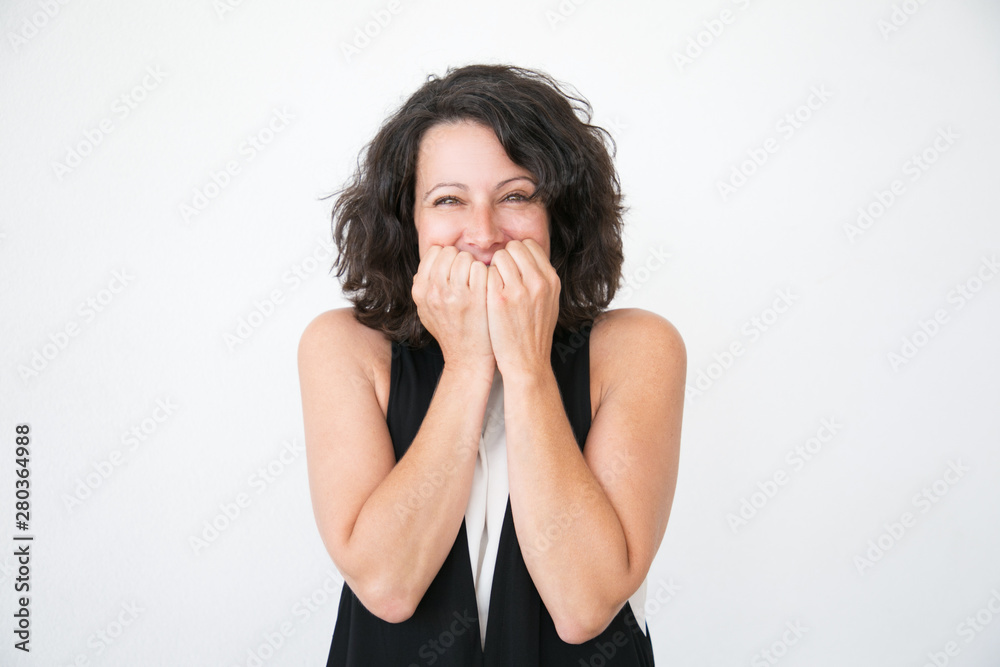 Happy excited woman in casual rejoicing at surprise or good news. Overjoyed middle aged woman covering mouth with hands and smiling at camera. Joy concept Happy excited woman in casual rejoicing at surprise or good news. Overjoyed middle aged woman covering mouth with hands and smiling at camera. Joy concept