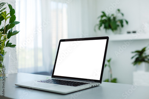 Close up Laptop Computer on Top of Office Table of a Businessman with Empty White Screen, Emphasizing Copy Space