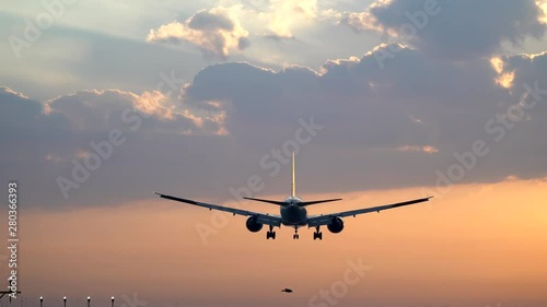 Tracking shot of airplane landing at dusk photo