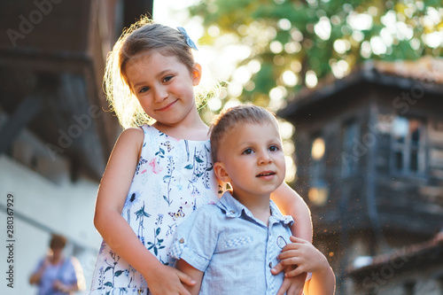 sister hugging younger brother