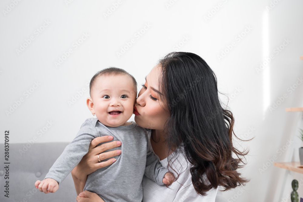 happy family at home. Mother holding baby daughter in living room in cozy weekend morning happy family at home. Mother holding baby daughter in living room in cozy weekend morning
