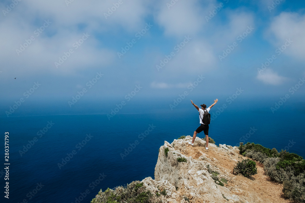 A young guy stands on the edge of a cliff. A young guy stands on the edge of a cliff.