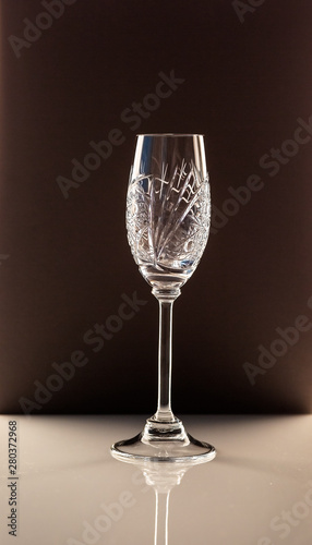 champagne glass standing on a white table against a dark background