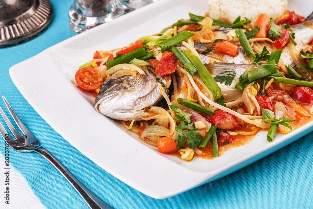Seafood, Mediterranean cuisine. Baked sea fish with mushrooms, herbs, carrots, millers, cilantro, corn and onions. Caucasian national cuisine Seafood, Mediterranean cuisine. Baked sea fish with mushrooms, herbs, carrots, millers, cilantro, corn and onions. Caucasian national cuisine