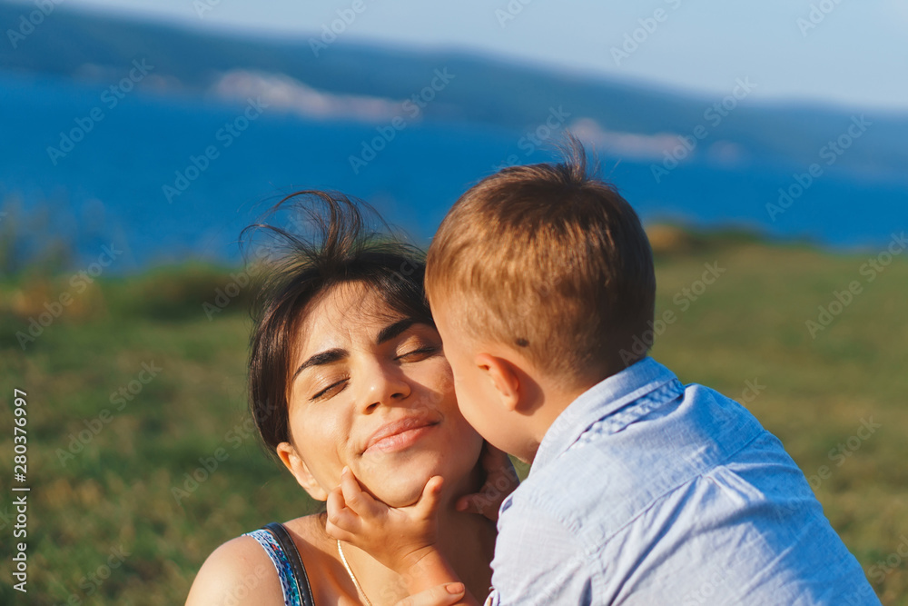 Fototapeta premium boy kissing mother on cheek