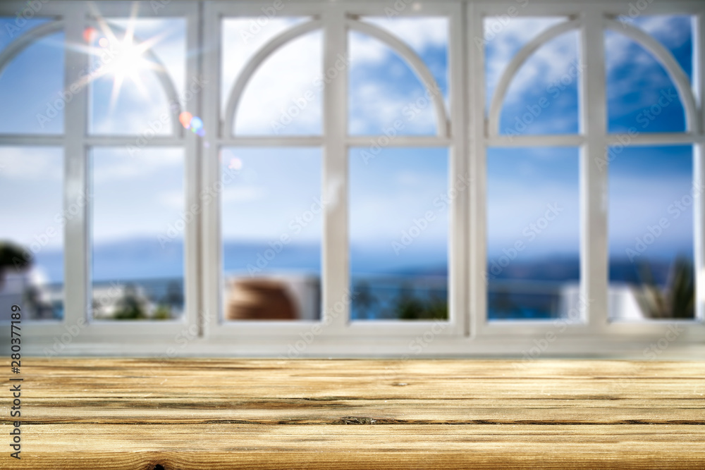 Fototapeta premium Table background with beautiful blue ocean and sandy beach view behind the window. Summer sunny day. Empty space for your decoration and advertising product.