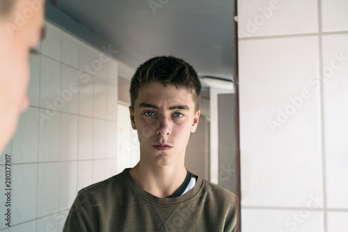 portrait of a serious young man in a mirror