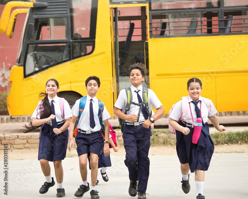 Schoolboys and schoolgirls walking of the school bus