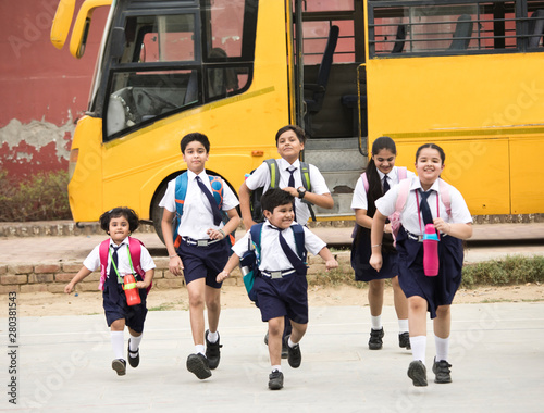 Schoolboys and schoolgirls walking of the school bus
