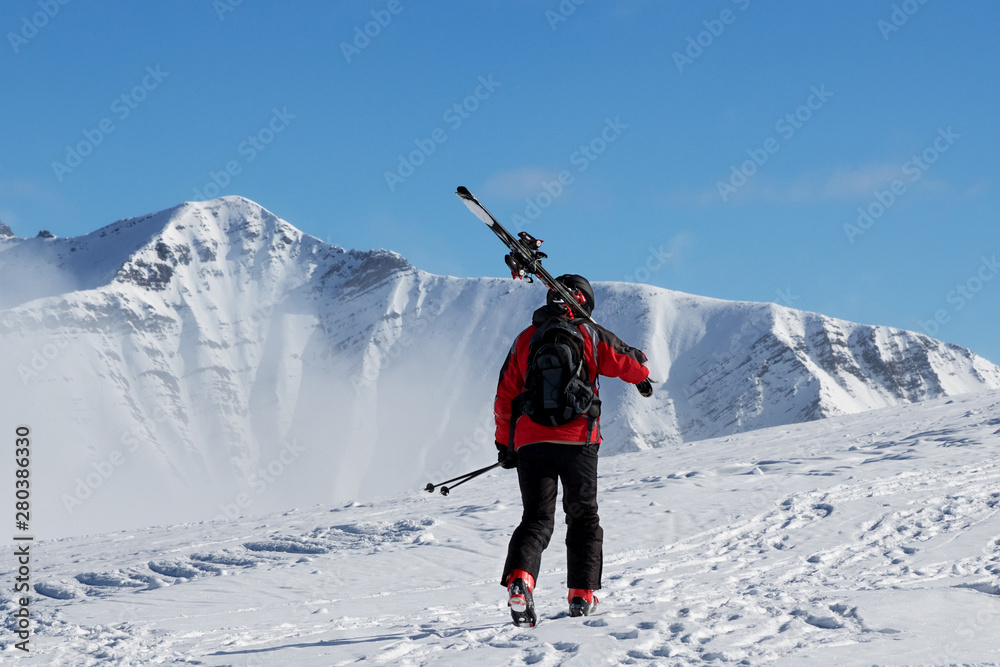 Skier with skis go up to top of mountain - obrazy, fototapety, plakaty 