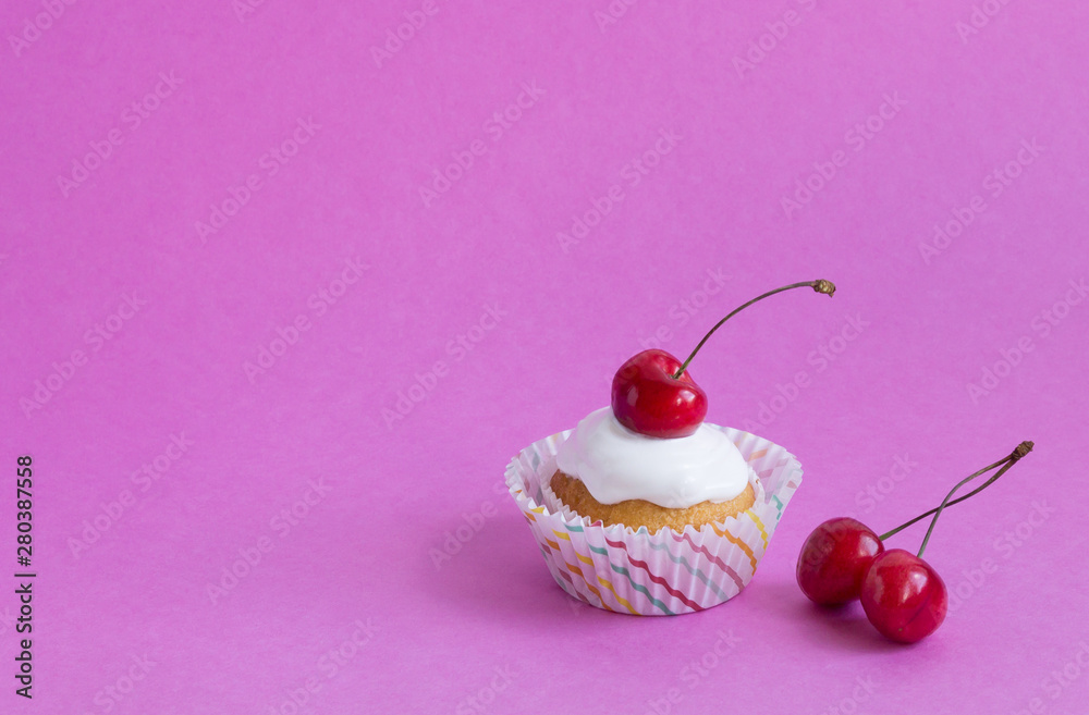 Cupcake with red cherry on pink background with copy space. Cupcake with red cherry on pink background with copy space.