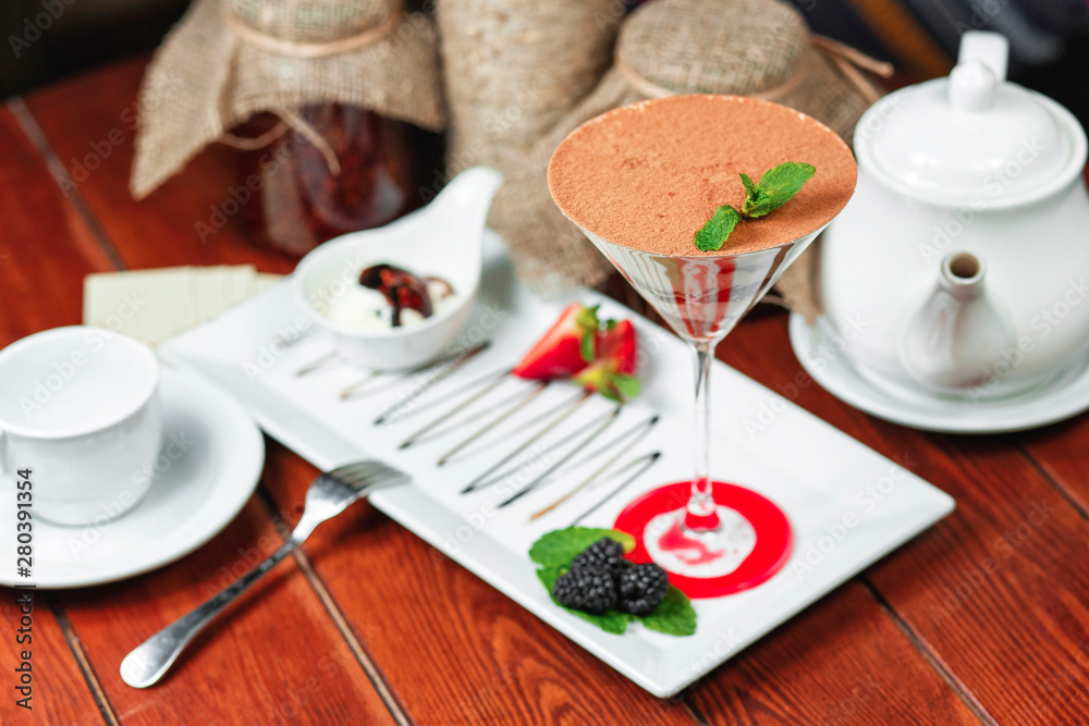 chocolate cake in a cocktail glass with nuts, sprinkled with sweet sauce with berries chocolate cake in a cocktail glass with nuts, sprinkled with sweet sauce with berries