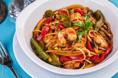 Mediterranean dish  Georgian recipe. Pasta with shrimps  red and green pepper  basil