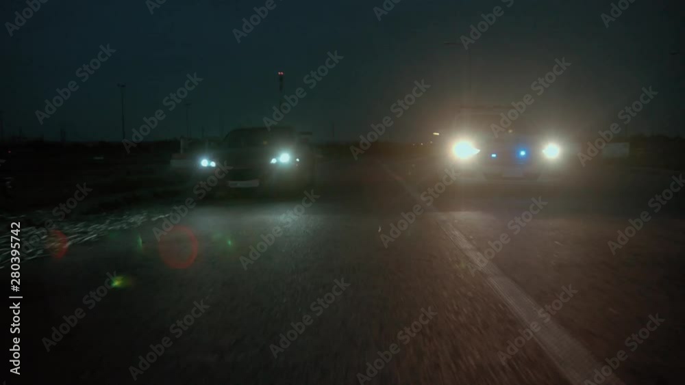Police pursuit at night. Police in action. View of policemen chasing a young couple on sports car in the city.