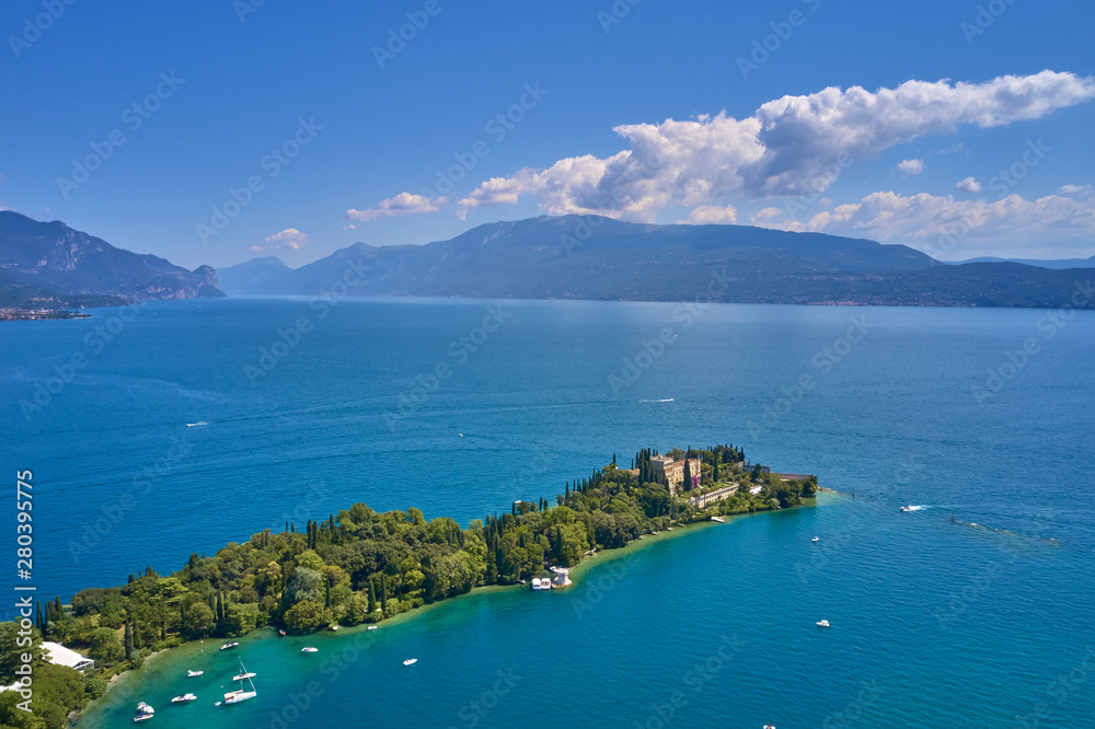 Unique view of the island of Garda. In the background is the Alps. Resort place on Lake Garda north of Italy. Aerial photography with drone.