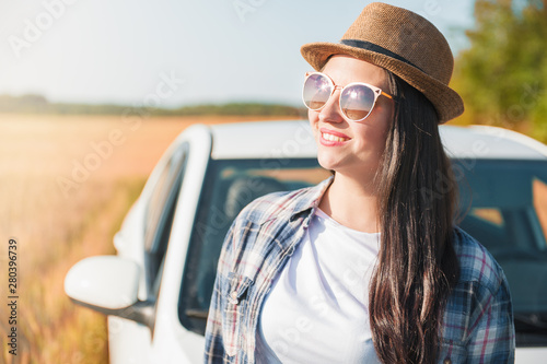 Beautiful woman portrait with white car in the summer field