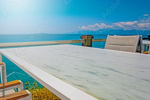 White table background with ocean and sunny blue sky view.