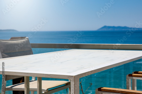White table background with ocean and sunny blue sky view.
