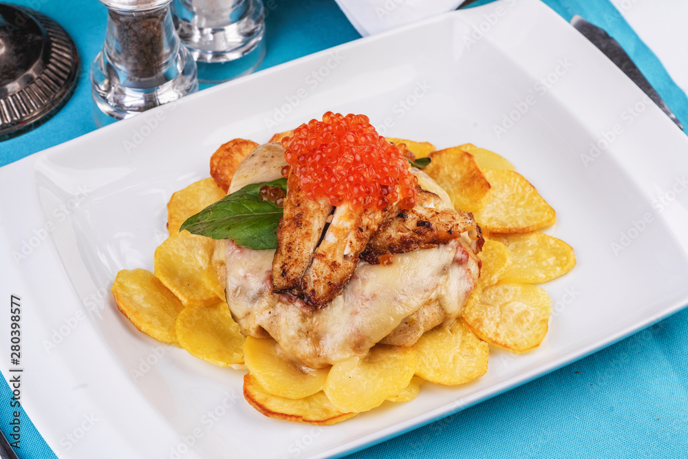 Seafood, Mediterranean cuisine, European dish. Sea salmon Fish steak with greens, country-style fried potatoes, cheese and cream sauce. Caucasian national cuisine