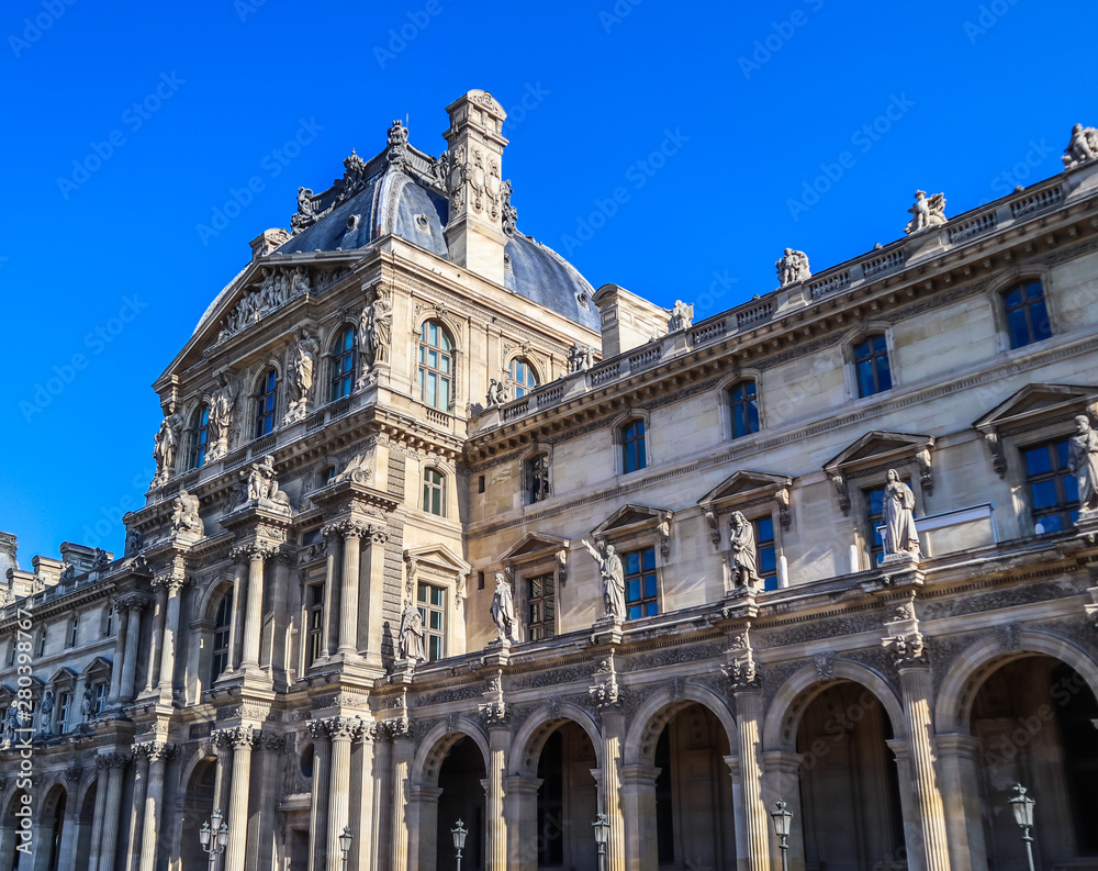 Architectural details of the facade of the Louvre palace in Paris, France. April 2019