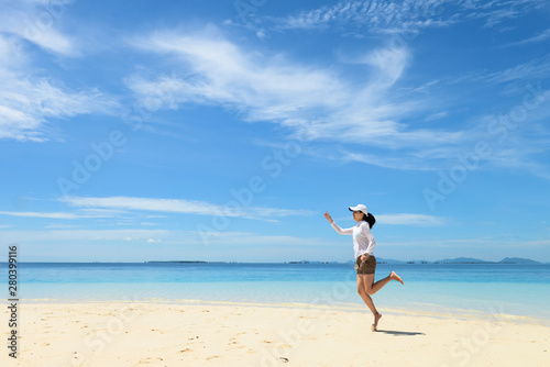 single young girl on tropical white sand beach running toward horizon. Semporna  Sabah  Malaysia