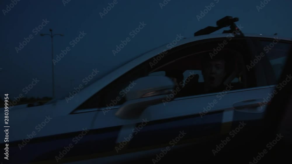 Police pull over at night. View in the car side rear mirror of police car outrace arrive and pull over the driver on the highway. Police pull over at night. View in the car side rear mirror of police car outrace arrive and pull over the driver on the highway.