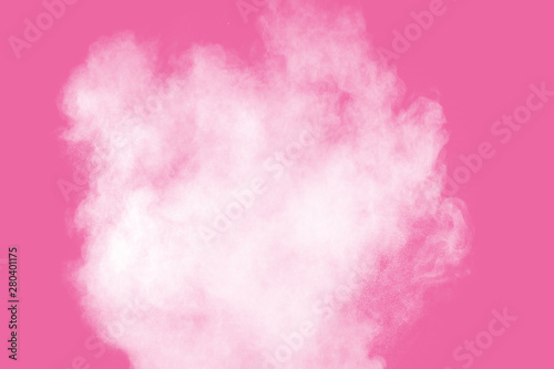 Abstract white powder explosion on pink background. Freeze motion of white dust splattered.