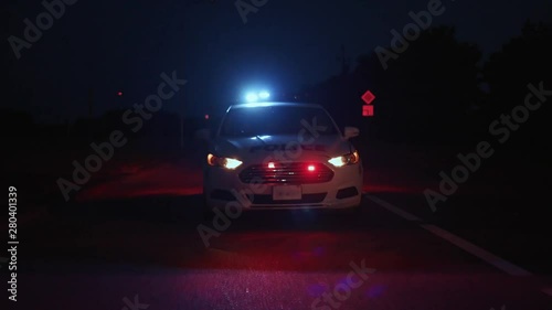 Police patrol car arriving in focus. Front view of policemen driving auto on the highway at night. Police raid in the city.