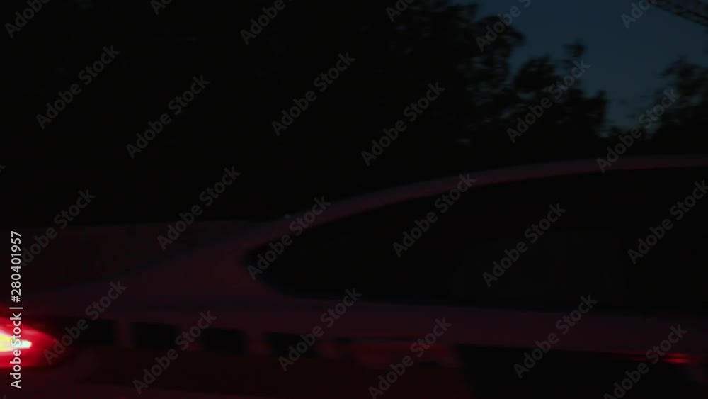 Police chase on emergency call. Side view of the high speed police patrol car driving to the road accident through suburbs at night. Police chase on emergency call. Side view of the high speed police patrol car driving to the road accident through suburbs at night.