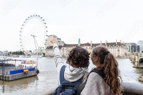 Carta da parati Two young teenagers stand indicate the London Eye