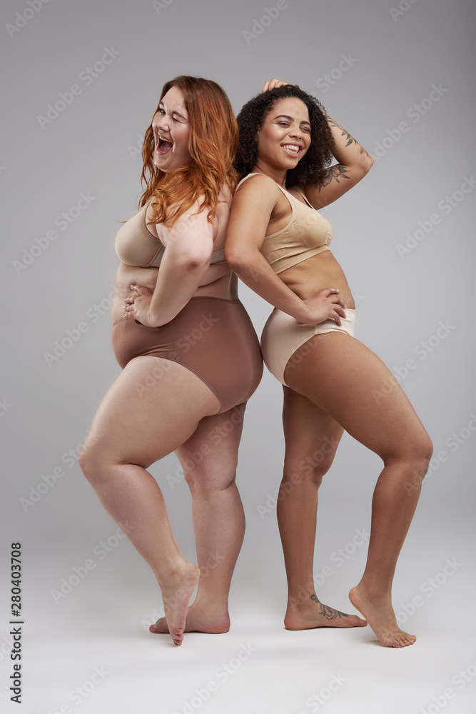 Two fat joyful female friends having good time in studio