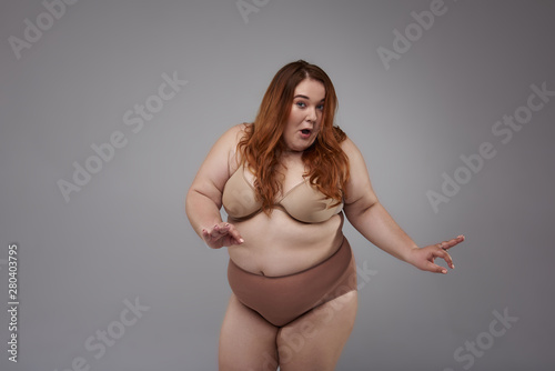 Plus size woman with red hair posing for camera © Yakobchuk Olena