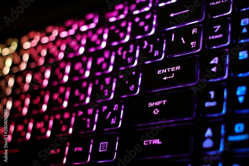 Colorful light from backlight of gamer laptop keyboard, Backlit in dark, Focused in enter button.