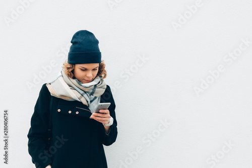 Young woman smiling and typing on mobile device © progressman