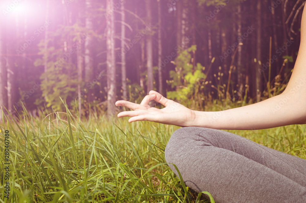Woman practicing yoga in the fresh air. Meditation on the background of the forest, hand close up. The concept of a healthy lifestyle. Place for text. Woman practicing yoga in the fresh air. Meditation on the background of the forest, hand close up. The concept of a healthy lifestyle. Place for text.